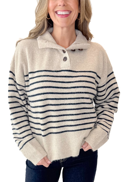Front detail view of woman wearing Oatmeal and Navy Striped Button Detail Sweater with jeans against white studio background.