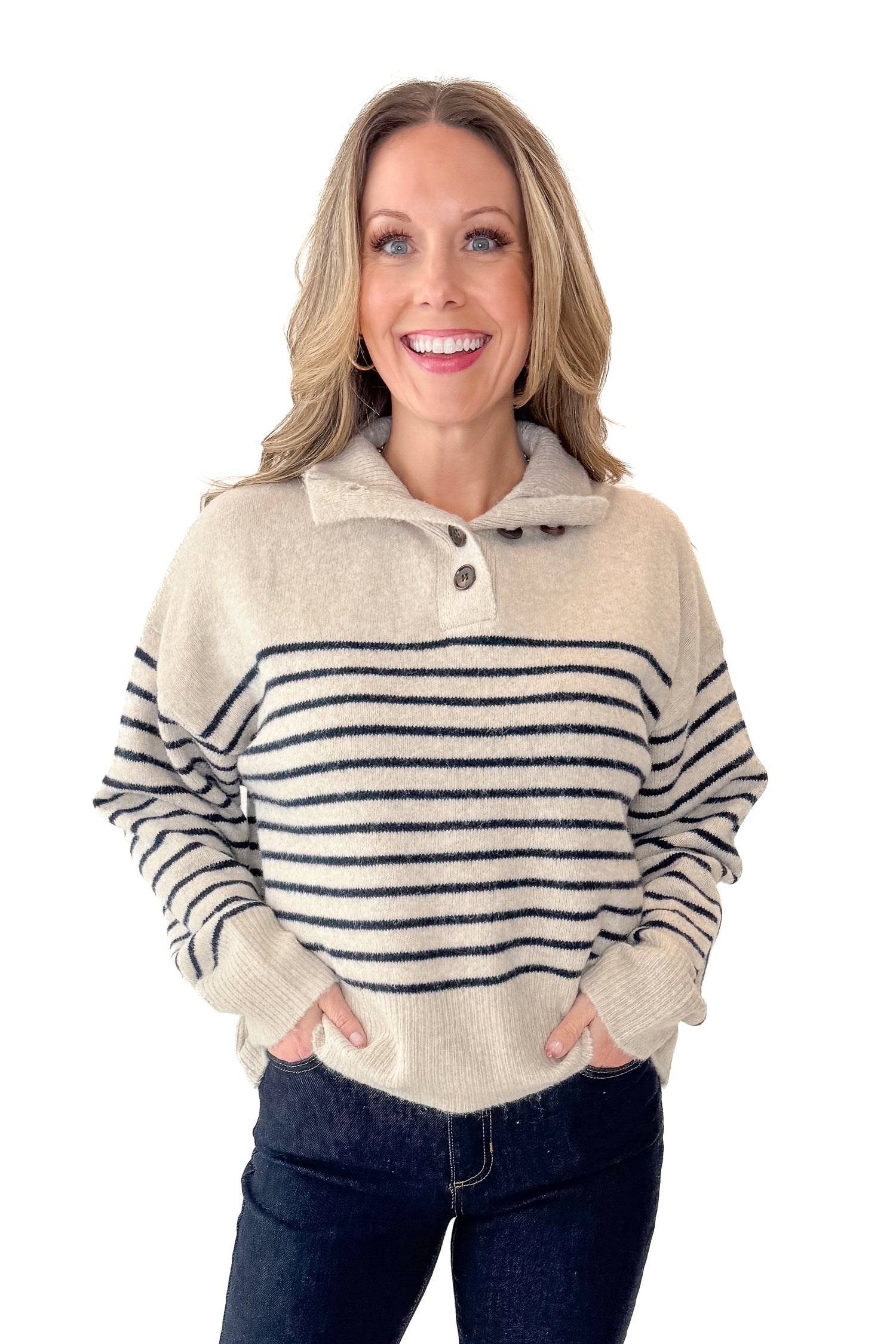 Front view of woman wearing Oatmeal and Navy Striped Button Detail Sweater with jeans against white studio background.