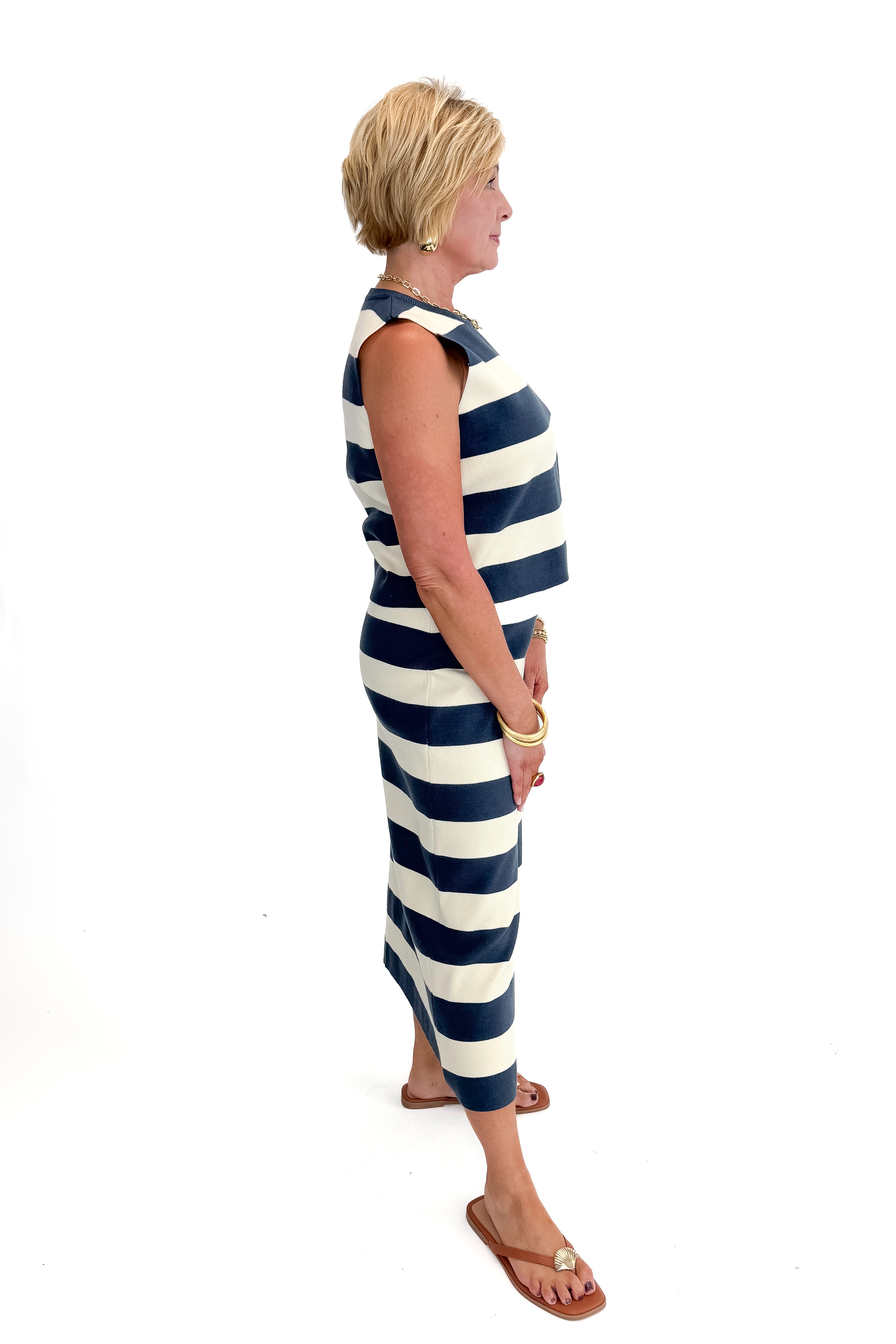 Side view of woman wearing Navy &amp; Cream Striped Midi Skirt with matching tank against white studio background.