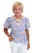 Front view of woman wearing Swagger Boutique’s Washed Blue Floral Puff Sleeve Top with jeans against white studio background.