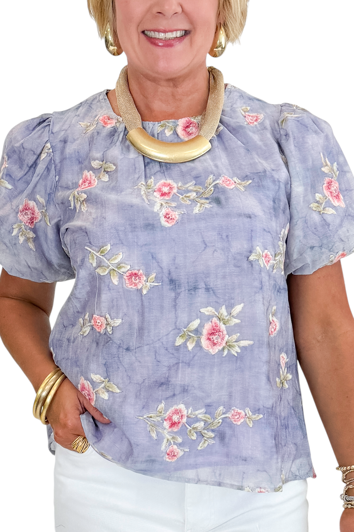 Front detail view of woman wearing Swagger Boutique’s Washed Blue Floral Puff Sleeve Top with jeans against white studio background.