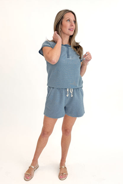 Front view of woman wearing Washed Blue Striped Drawstring Shorts with matching top against white studio background.