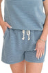 Front detail view of woman wearing Washed Blue Striped Drawstring Shorts with matching top against white studio background.
