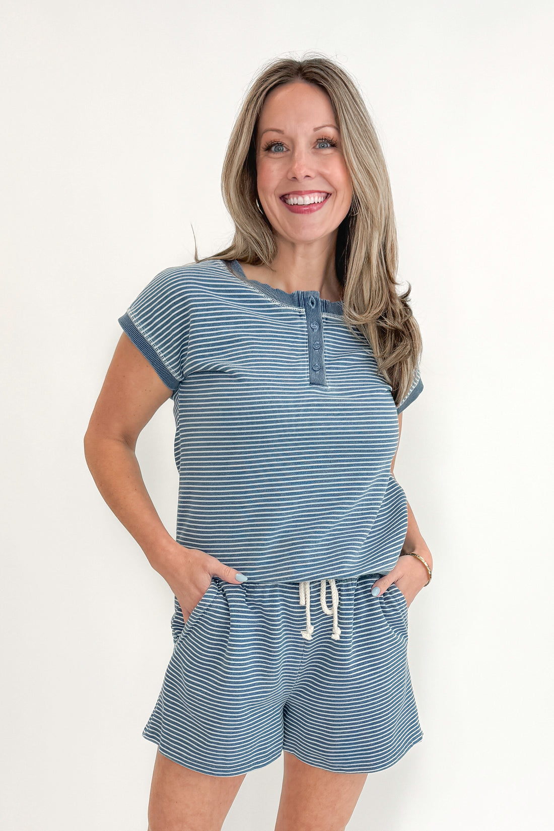 Front view of woman wearing Washed Blue Striped Drawstring Shorts with matching top against white studio background.