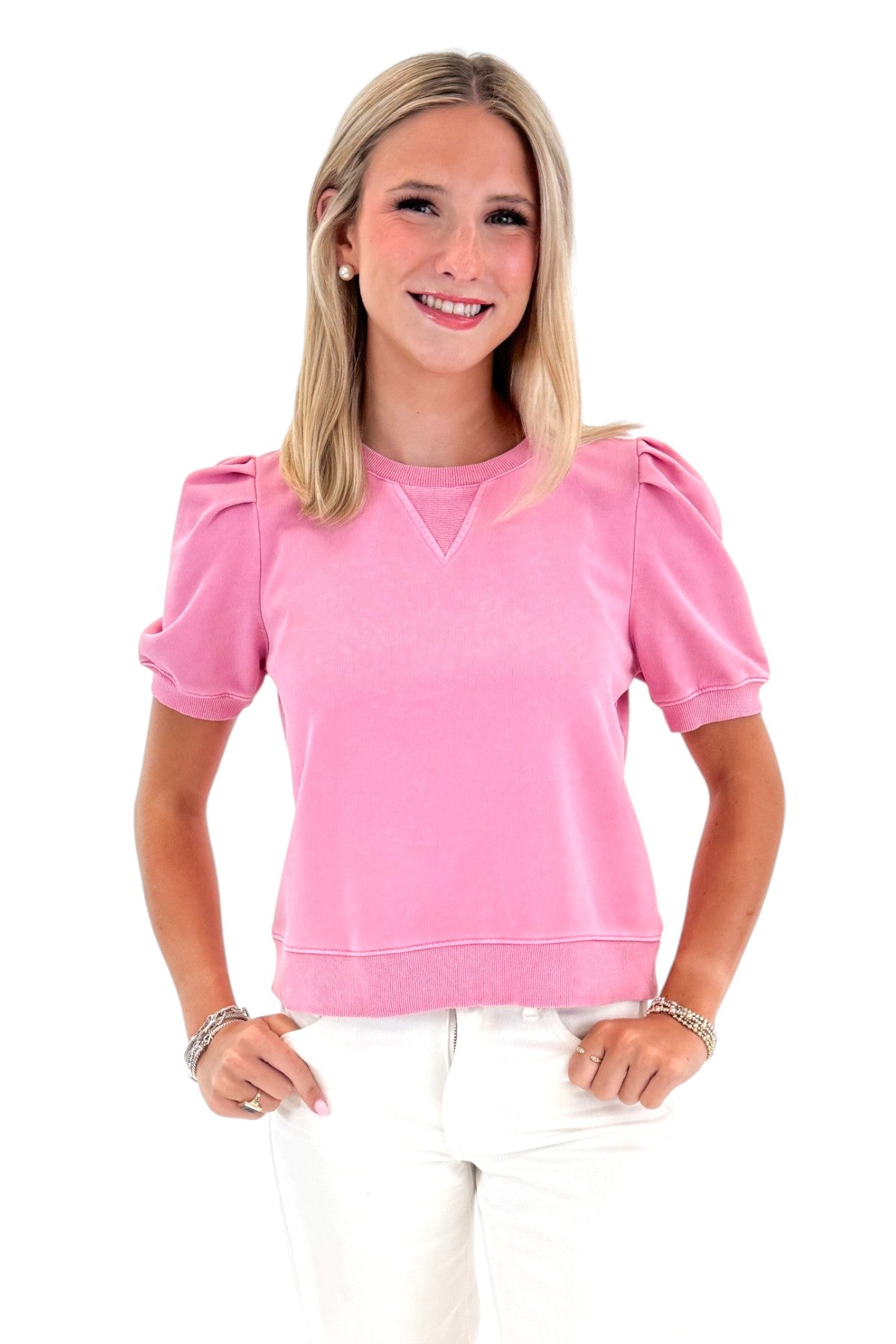 Front view of woman wearing Swagger Boutique’s Washed Pink Short Sleeve Sweatshirt with jeans against white studio background.