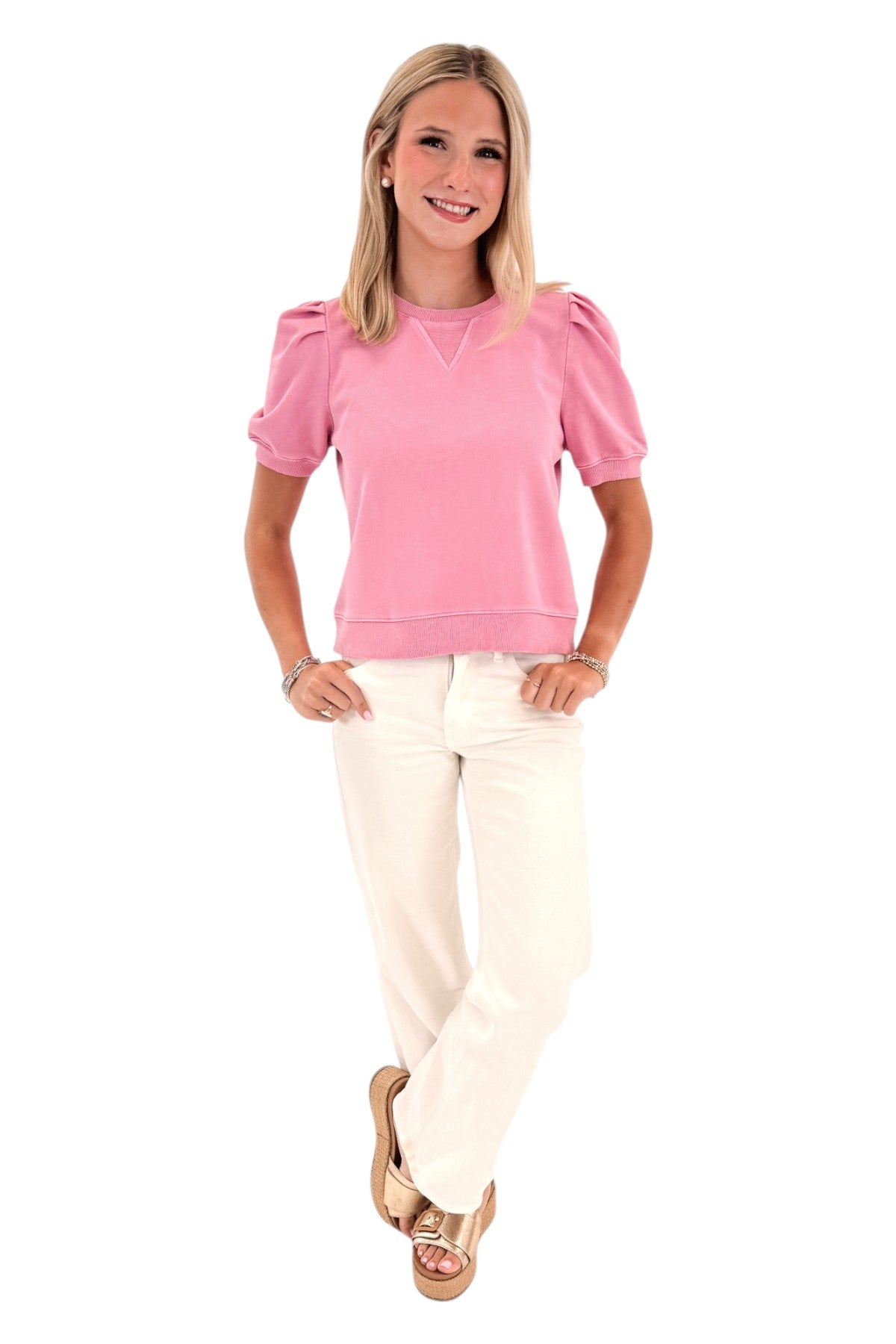 Front view of woman wearing Swagger Boutique’s Washed Pink Short Sleeve Sweatshirt with jeans against white studio background.