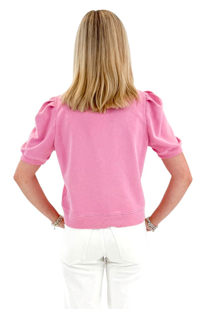 Back view of woman wearing Swagger Boutique’s Washed Pink Short Sleeve Sweatshirt with jeans against white studio background.