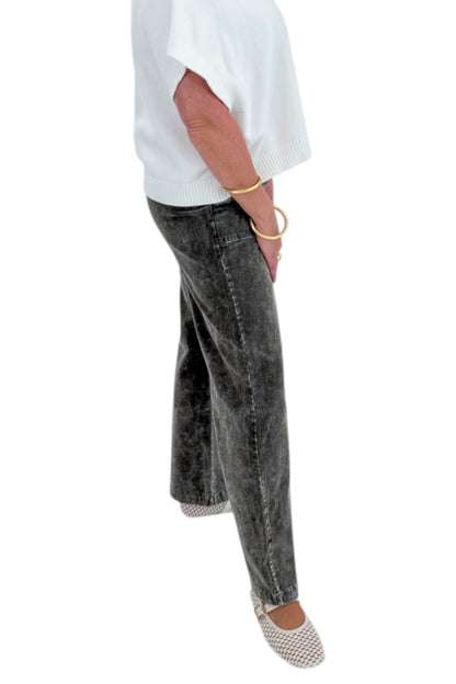 Side view of woman wearing Swagger Boutique’s Ivory Light Weight Short Sleeve Sweater with Washed Stone Corduroy Pants against white studio background.