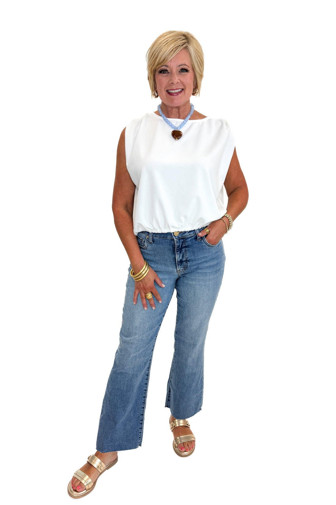 Front view of woman wearing Swagger Boutique’s White Bubble Hem Tank with jeans against white studio background.