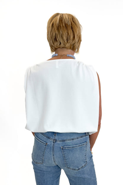 Back view of woman wearing Swagger Boutique’s White Bubble Hem Tank with jeans against white studio background.