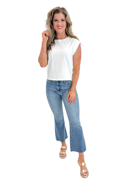 Front view of woman wearing Swagger Boutique’s White Camino Jersey Top by Z Supply with jeans against white studio background.