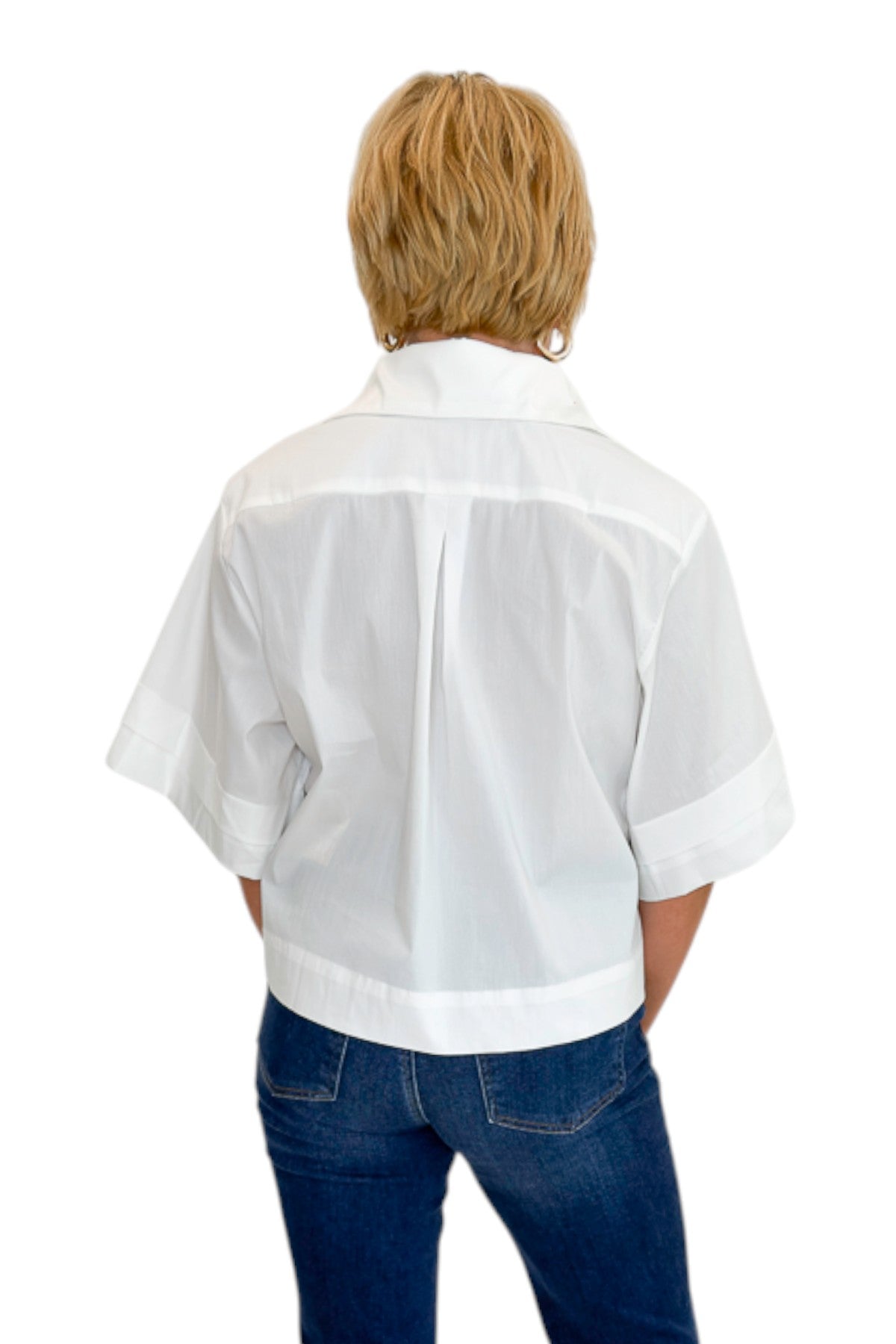 Back view of woman wearing Swagger Boutique’s White Collared Short Sleeve Top with jeans against white studio background.