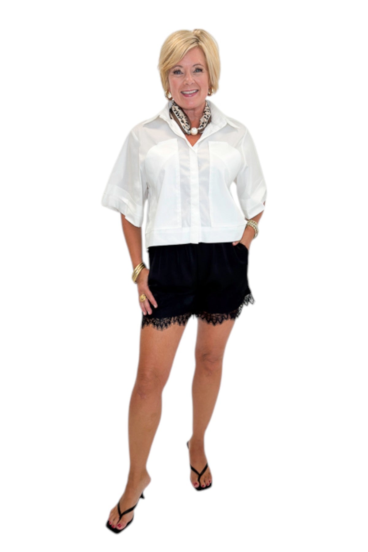 Front view of woman wearing Swagger Boutique’s White Collared Short Sleeve Top with Black Lace Hem Shorts by Entro against white studio background.