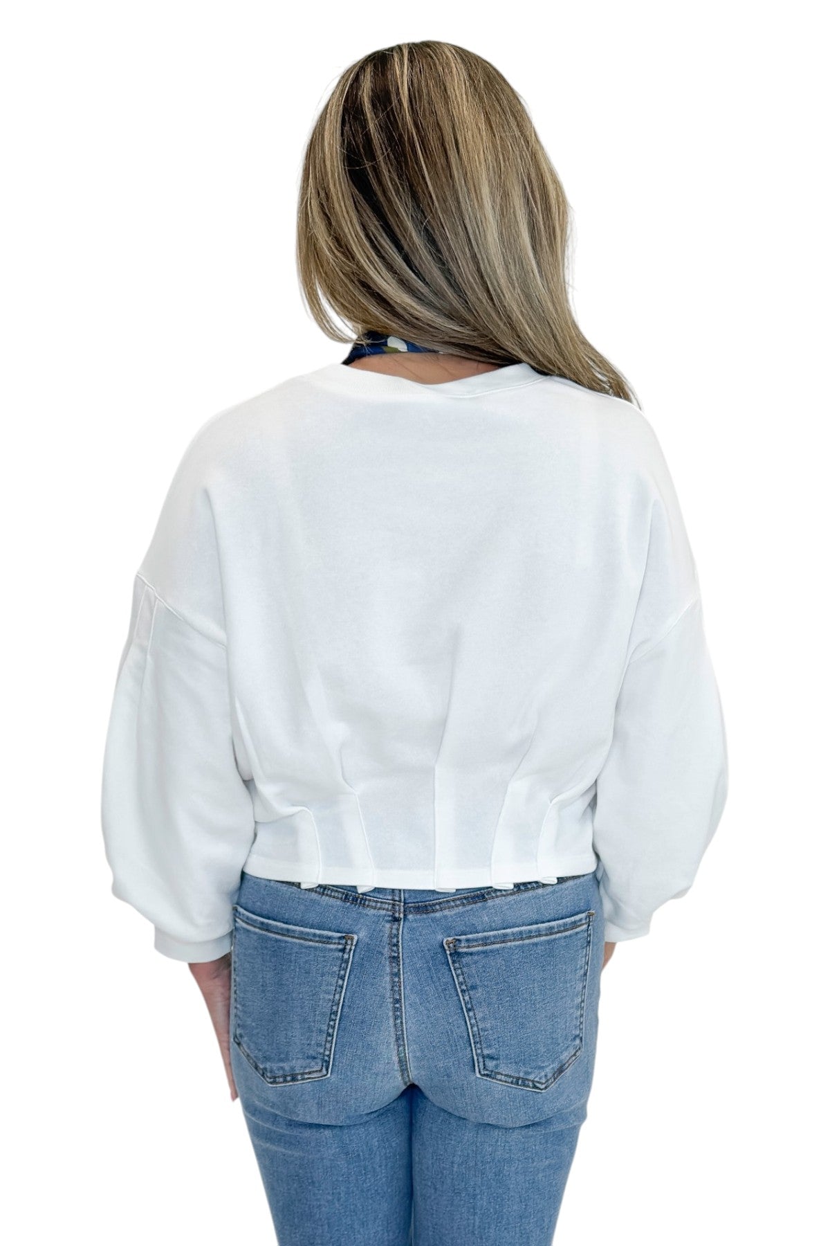 Back view of woman wearing Swagger Boutique’s White Cropped 3/4 Sleeve Sweatshirt by Entro with jeans against white studio background.