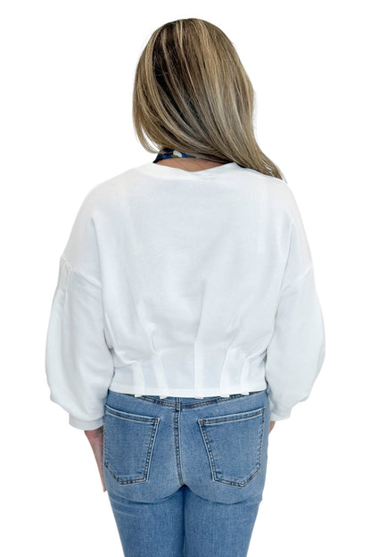 Back view of woman wearing Swagger Boutique’s White Cropped 3/4 Sleeve Sweatshirt by Entro with jeans against white studio background.