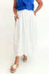 Front view of woman wearing Swagger Boutique’s Blue Sleeveless Tank With Twist by Skies Are Blue with White Embroidered Skirt against white studio background.