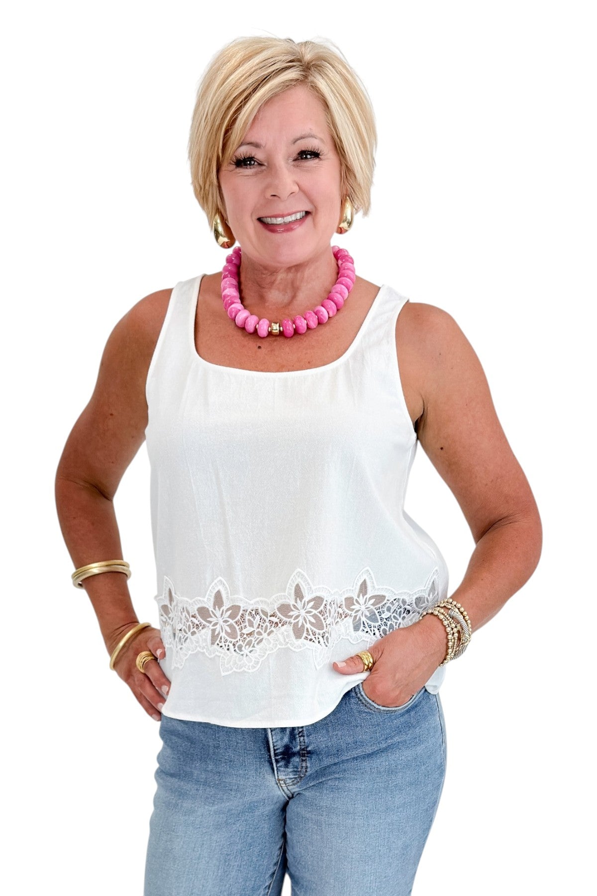 Front view of woman wearing Swagger Boutique’s White Lace Embroidered Detail Tank with jeans against white studio background.