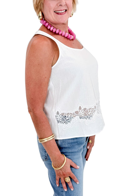 Side view of woman wearing Swagger Boutique’s White Lace Embroidered Detail Tank with jeans against white studio background.