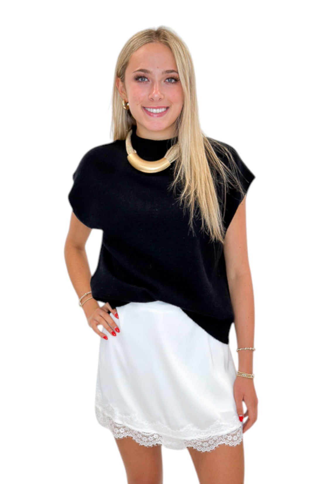 Front view of woman wearing Swagger Boutique’s Black Sleeveless Sweater by Entro with White Lace Trim Satin Mini Skirt against white studio background.