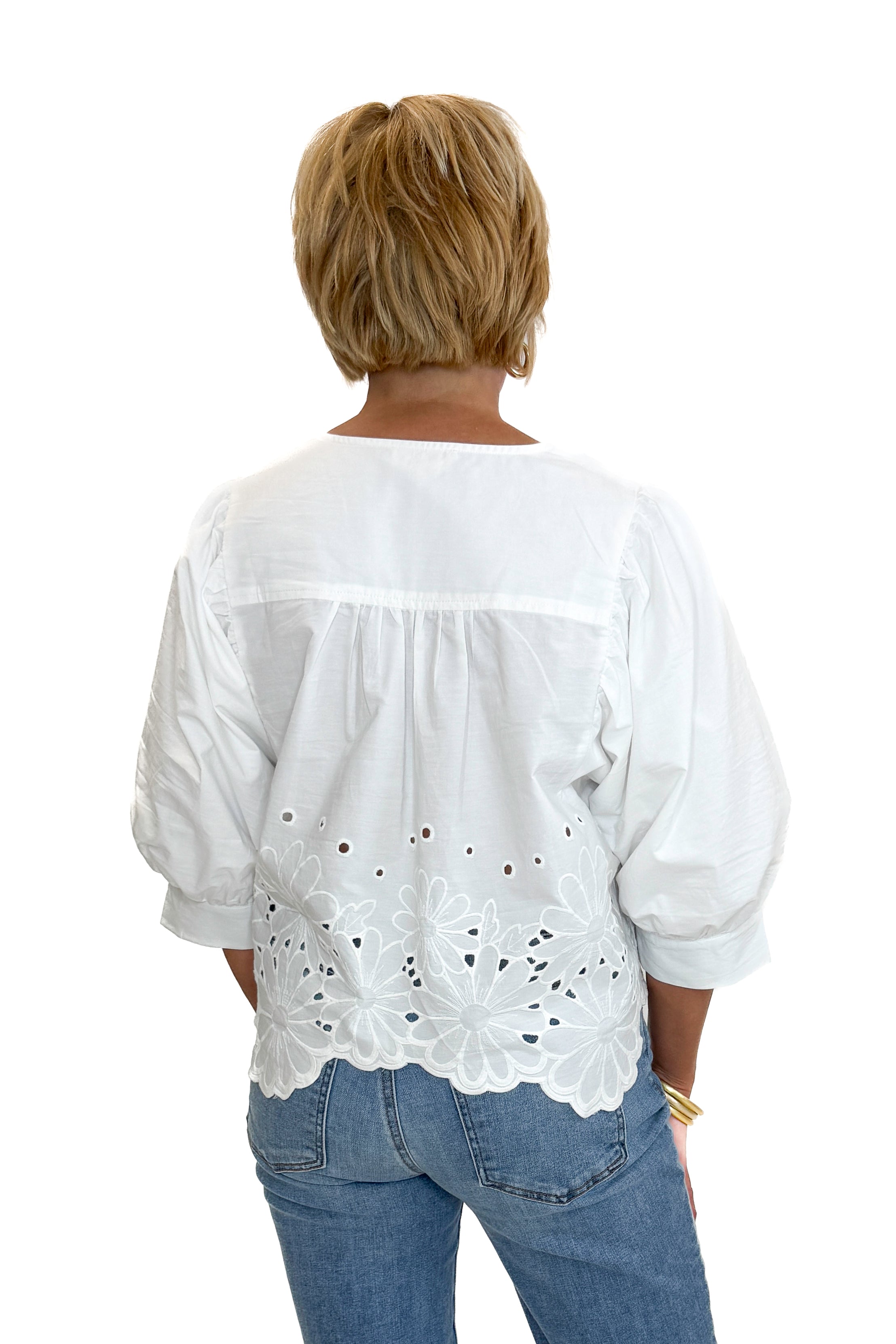 Back view of woman wearing Swagger Boutique’s White Puff Sleeve Eyelet Top with jeans against white studio background.