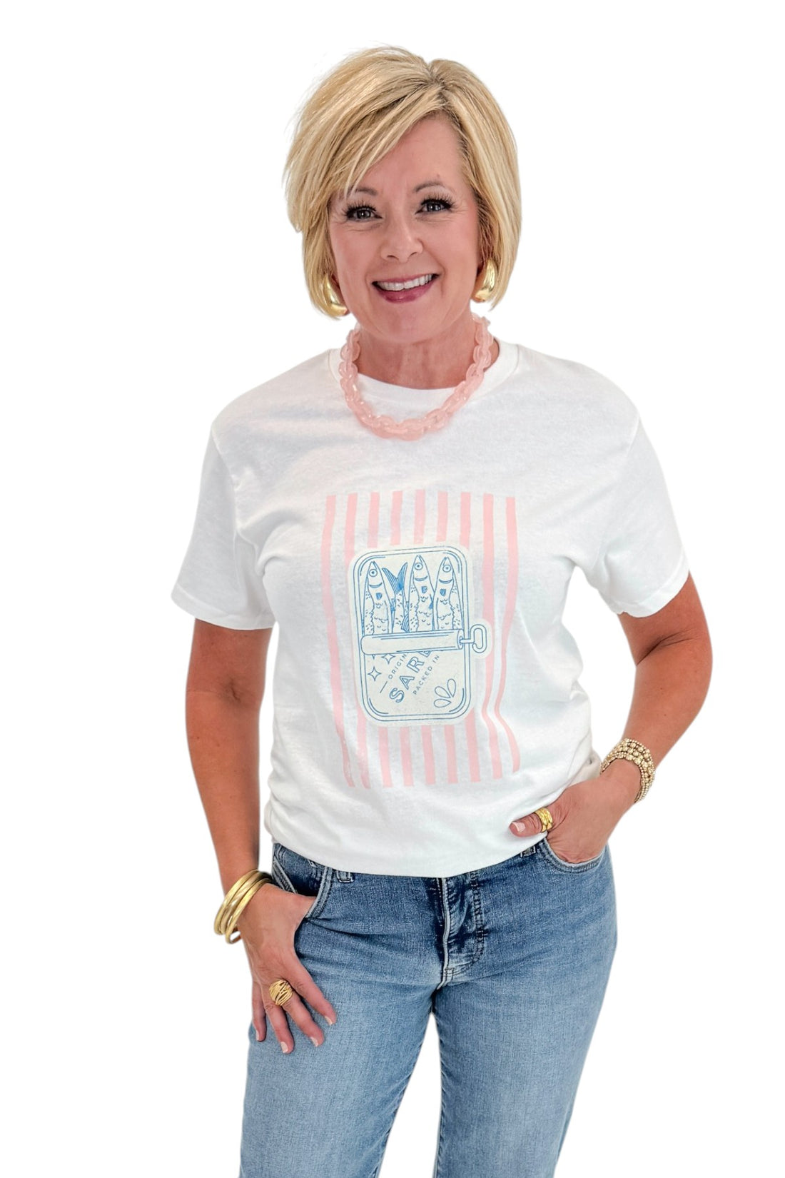 Front view of woman wearing Swagger Boutique’s White Sardine Graphic T-Shirt with jeans against white studio background.