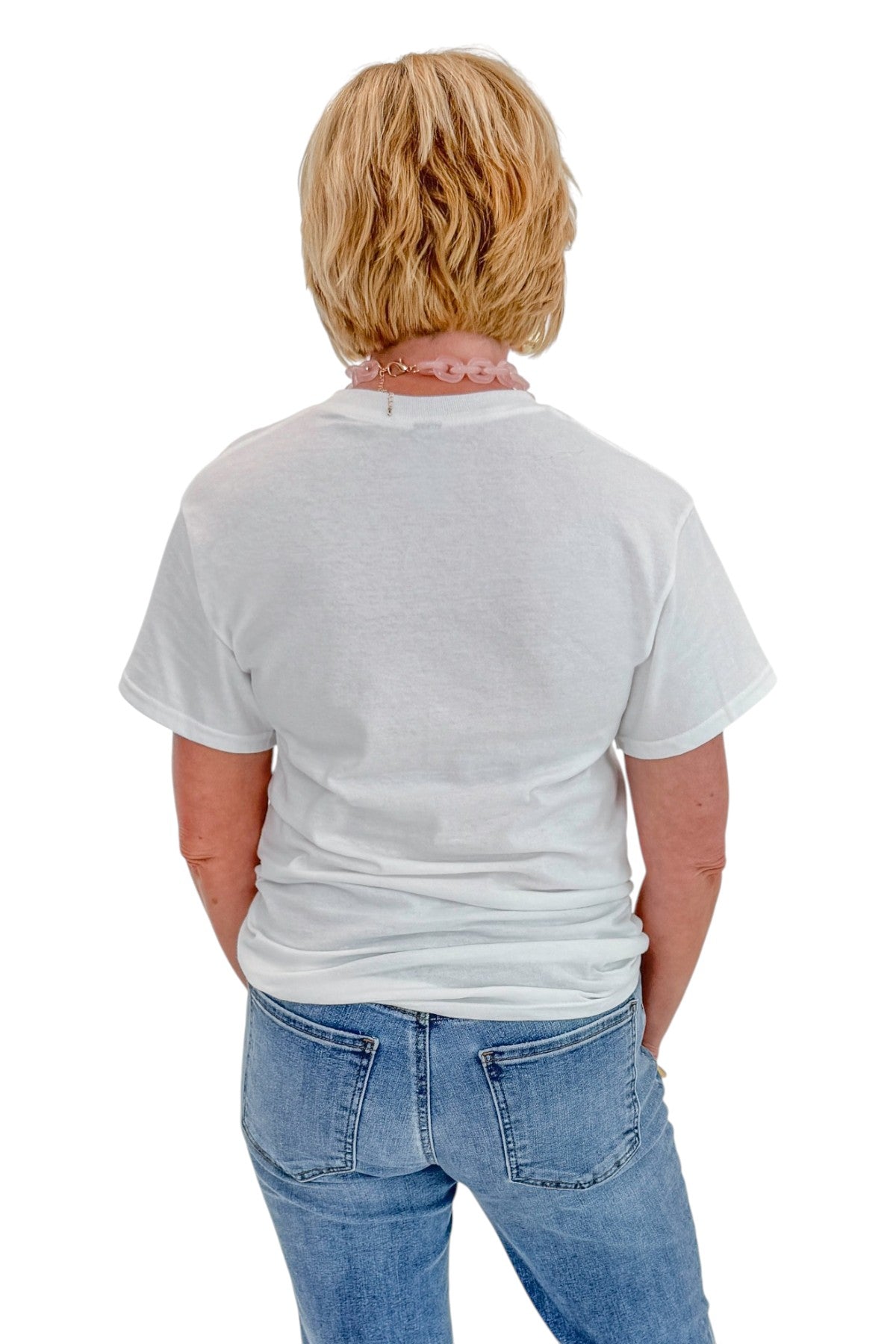 Back view of woman wearing Swagger Boutique’s White Sardine Graphic T-Shirt with jeans against white studio background.