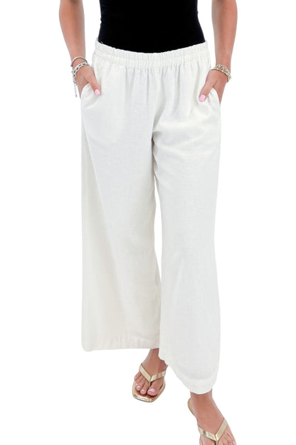 Front detail view of woman wearing Swagger Boutique’s White Scout Linen Pants by Z Supply with top against white studio background.