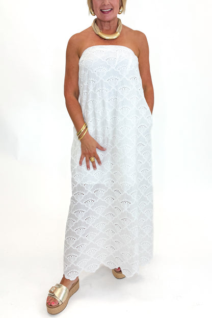 Front detail view of woman wearing Swagger Boutique’s White Strapless Eyelet Midi Dress by Entro with sandals against white studio background.