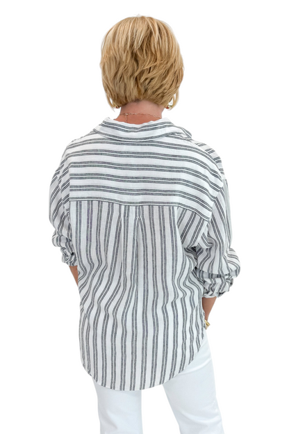Back view of woman wearing Swagger Boutique’s White The Perfect Striped Button Up Top by Z Supply with jeans against white studio background.