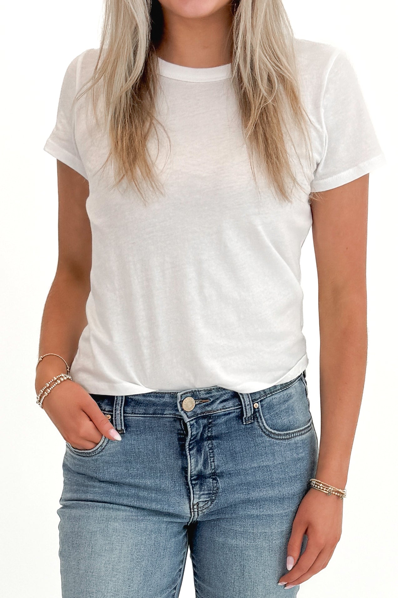 Front detail view of woman wearing Swagger Boutique’s White Tourist Tee by Z Supply with jeans against white studio background.