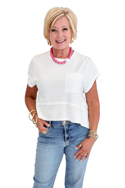 Front view of woman wearing Swagger Boutique’s White Waffle Knit Tee with jeans against white studio background.