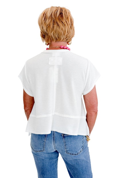 Back view of woman wearing Swagger Boutique’s White Waffle Knit Tee with jeans against white studio background.