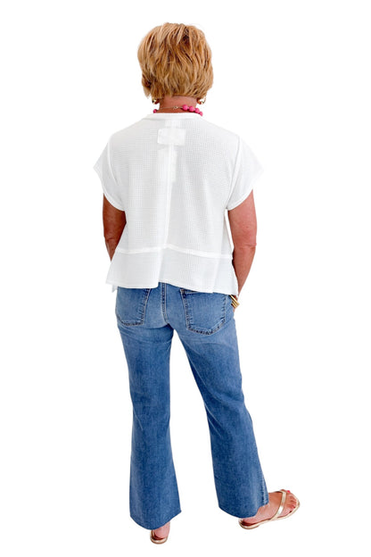 Back view of woman wearing Swagger Boutique’s White Waffle Knit Tee with jeans against white studio background.