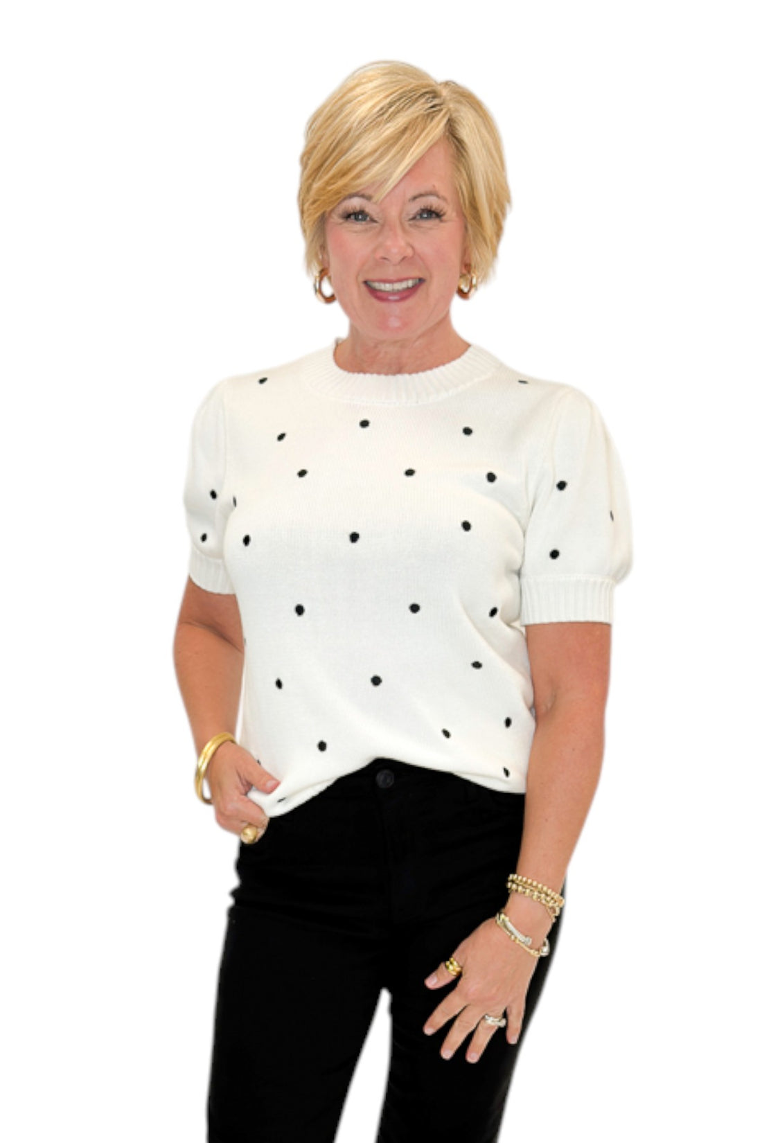 Front view of woman wearing Swagger Boutique’s White With Black Polka Dot Short Sleeve Sweater with jeans against white studio background.