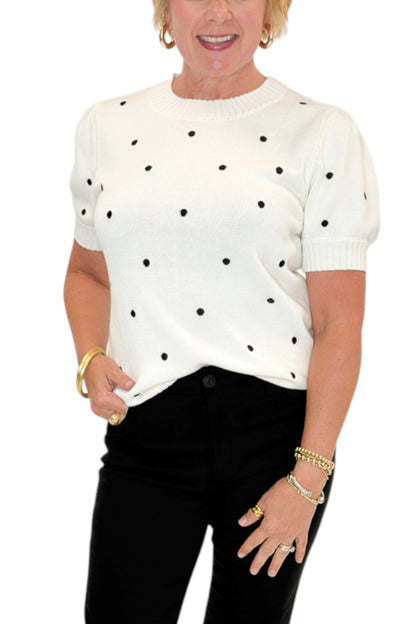 Front detail view of woman wearing Swagger Boutique’s White With Black Polka Dot Short Sleeve Sweater with jeans against white studio background.
