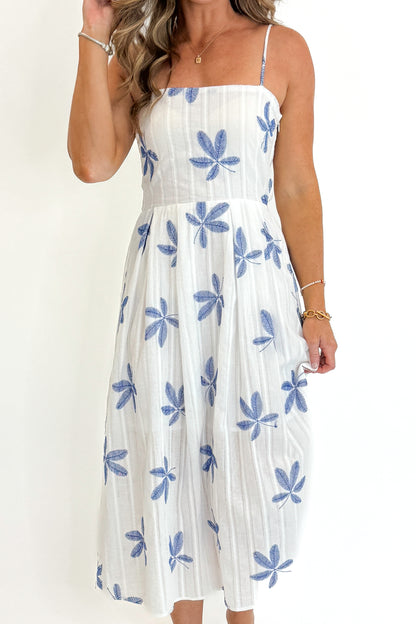 Front detail view of woman wearing Swagger Boutique’s White With Blue Embroidery Midi Dress against white studio background.