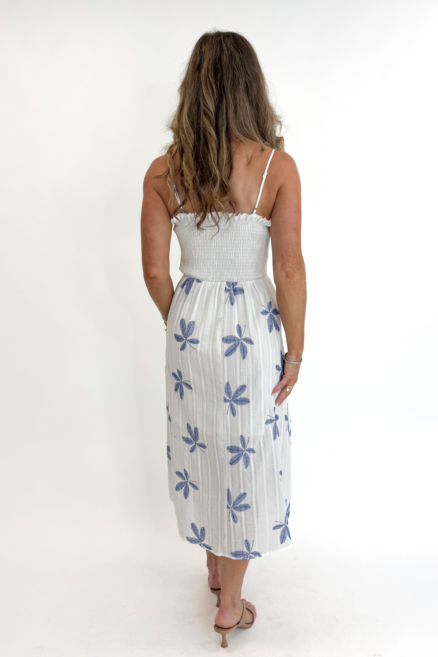 Back view of woman wearing Swagger Boutique’s White With Blue Embroidery Midi Dress against white studio background.