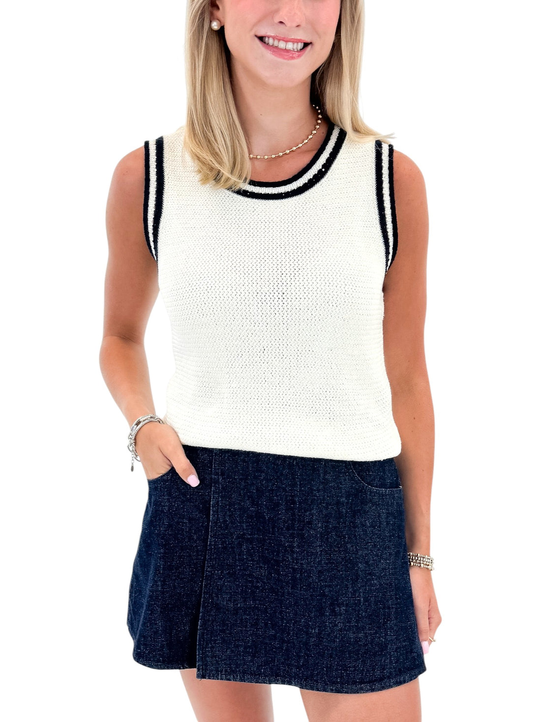 Front view of woman wearing Swagger Boutique’s White With Navy Lining Sweater Tank by Skies Are Blue with skort against white studio background.