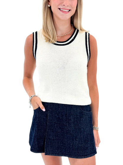 Front view of woman wearing Swagger Boutique’s White With Navy Lining Sweater Tank by Skies Are Blue with skort against white studio background.