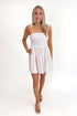 Front view of woman wearing Swagger Boutique’s White With Red Polka Dots Tie Strap Dress with sandals against white studio background.