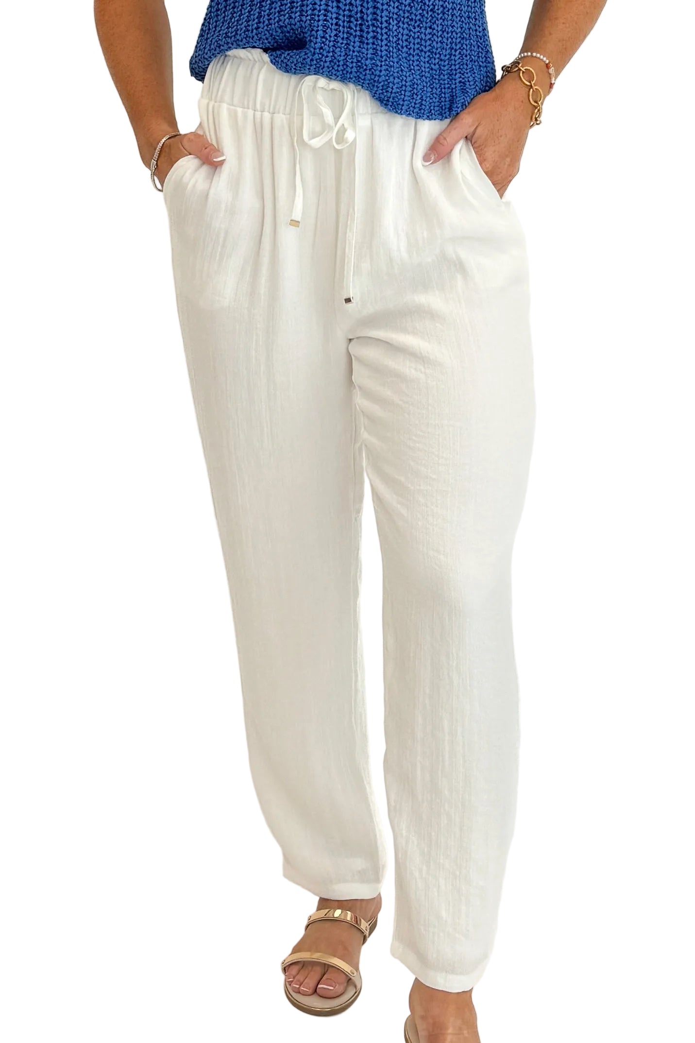 Front detail view of woman wearing Swagger Boutique’s White Woven Pants with blue tank against white studio background.