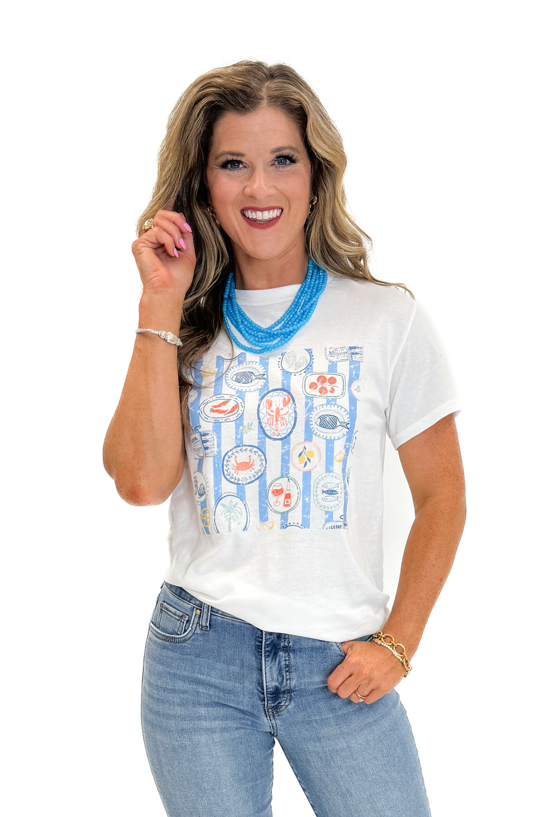 Front view of woman wearing Swagger Boutique’s White &amp; Blue Printed Graphic T-Shirt with jeans against white studio background.