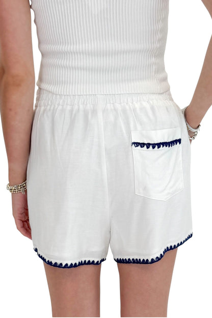 Back detail view of woman wearing Swagger Boutique’s White &amp; Blue Square Neck Stitch Detail Tank with Off White Ribbed Tube Top against white studio background.