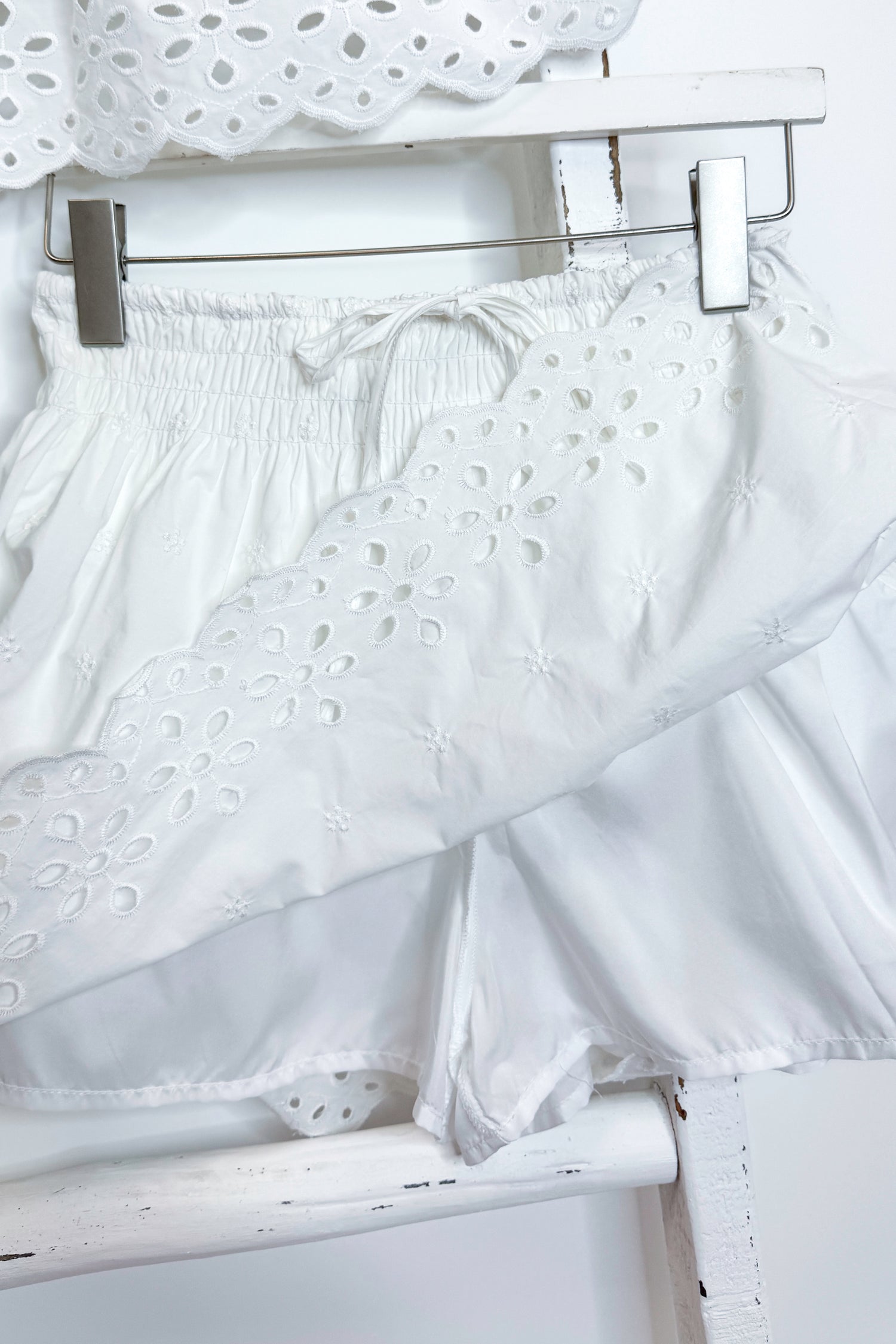 White eyelet skirt with hidden shorts against white background.