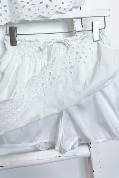 White eyelet skirt with hidden shorts against white background.