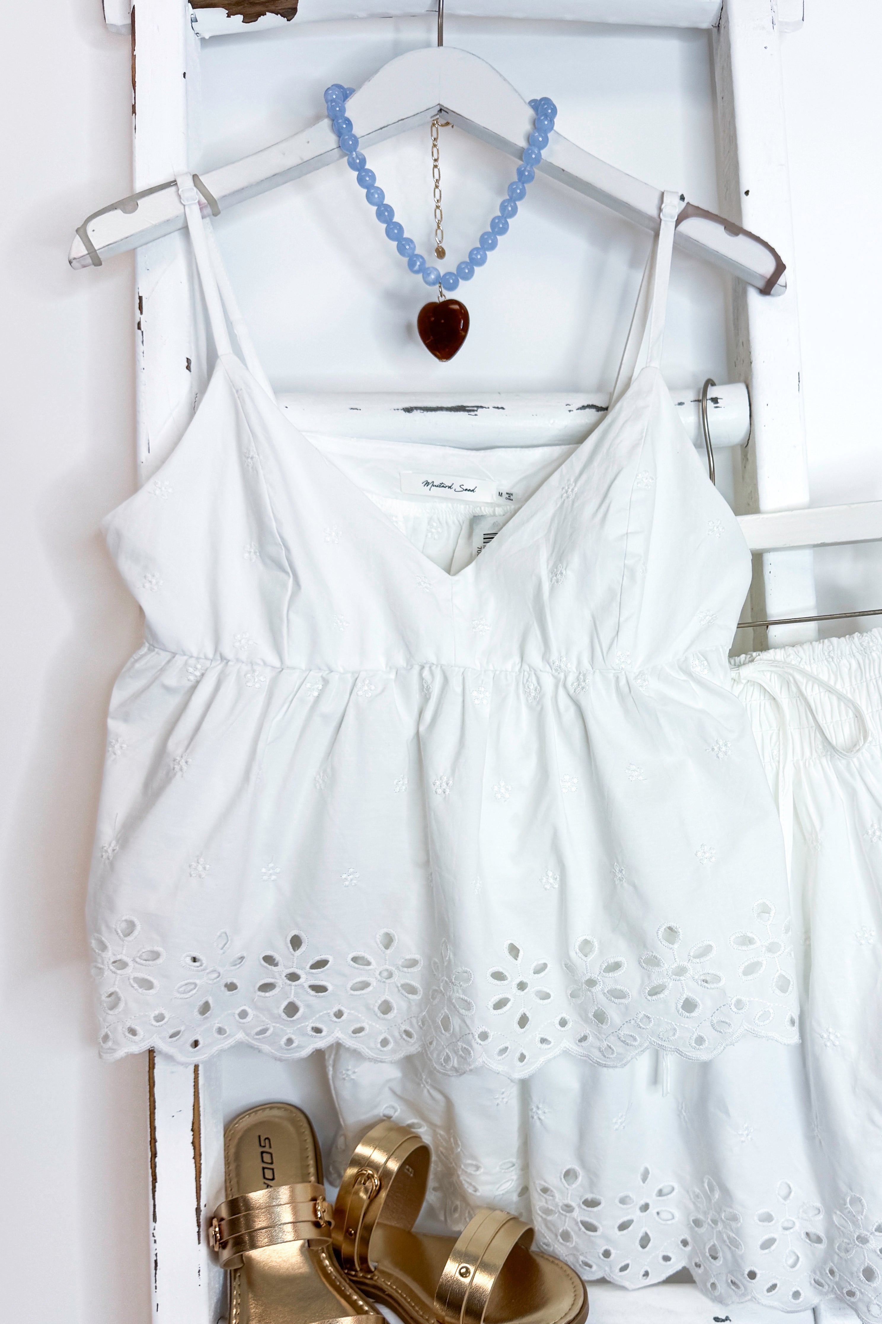 White eyelet skirt and tank with sandals against white background.