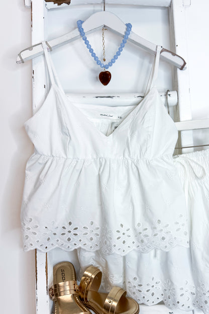 White eyelet skirt and tank with sandals against white background.