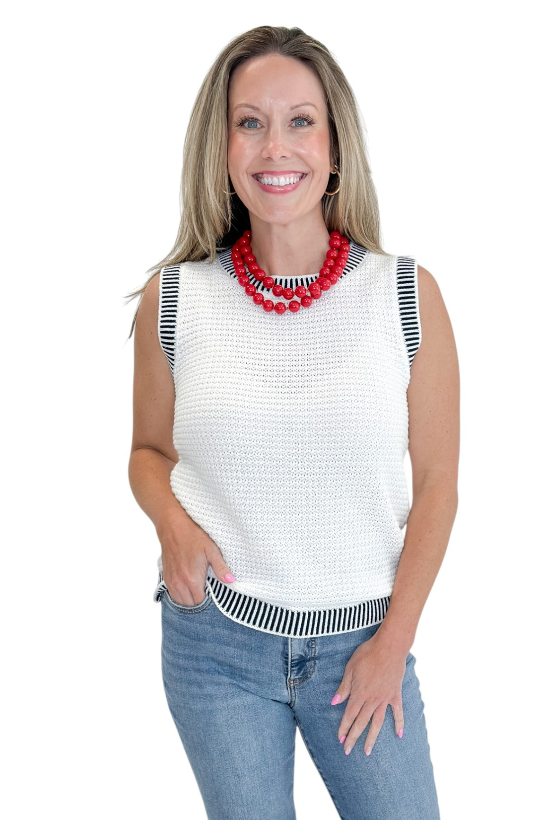 Front view of woman wearing Swagger Boutique’s White &amp; Navy Textured Sweater Tank with jeans against white studio background.