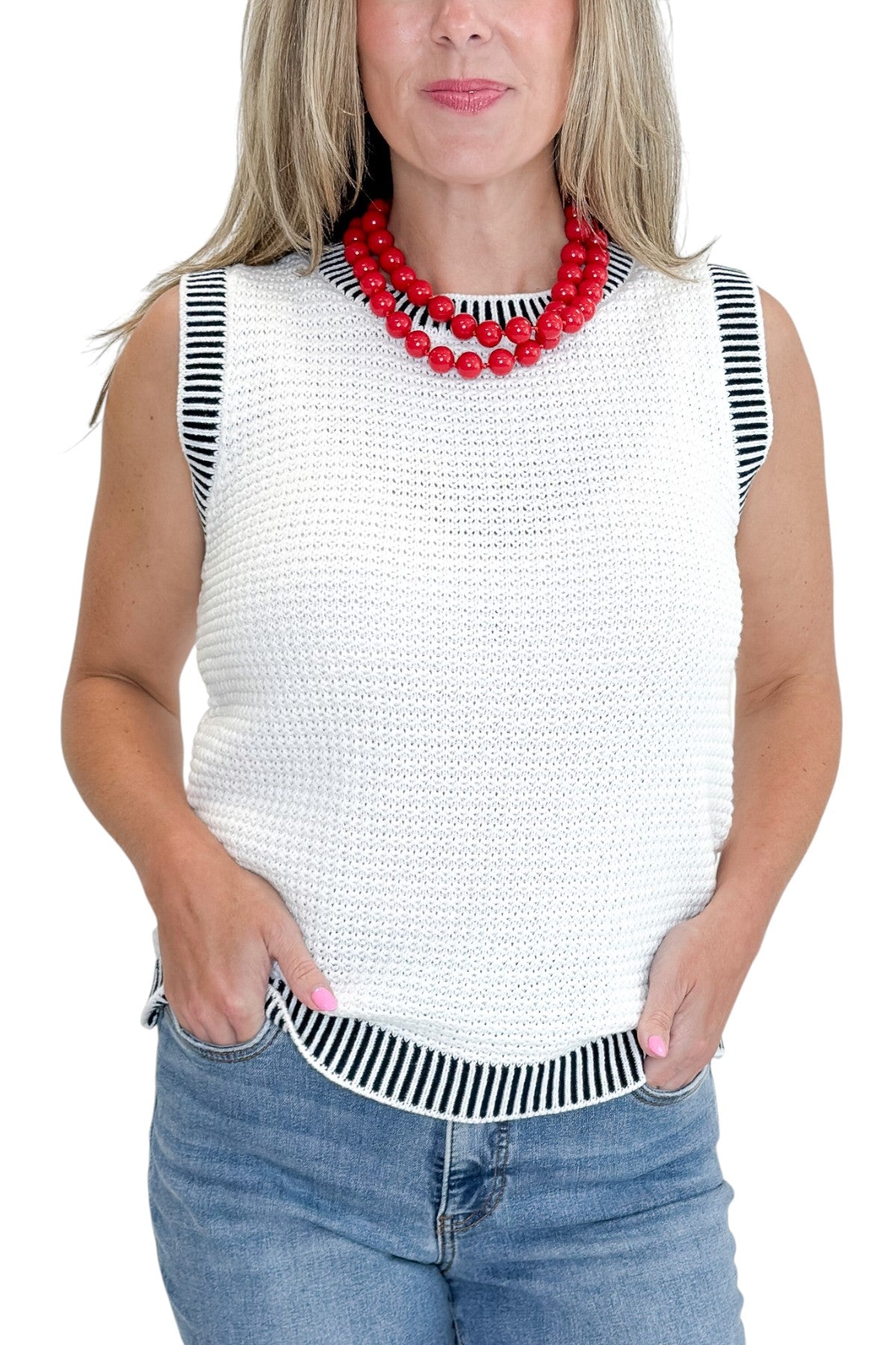 Front detail view of woman wearing Swagger Boutique’s White &amp; Navy Textured Sweater Tank with jeans against white studio background.