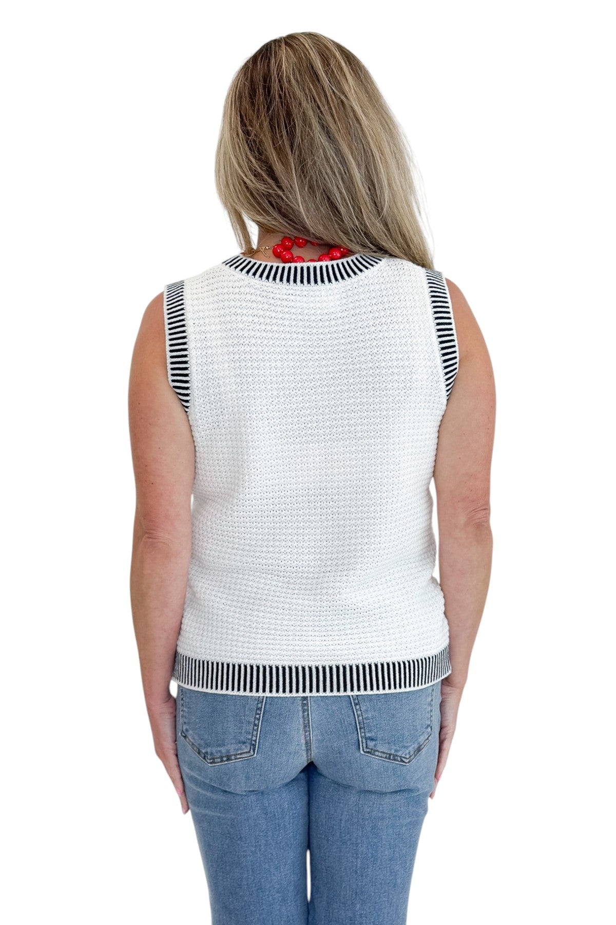 Back view of woman wearing Swagger Boutique’s White &amp; Navy Textured Sweater Tank with jeans against white studio background.